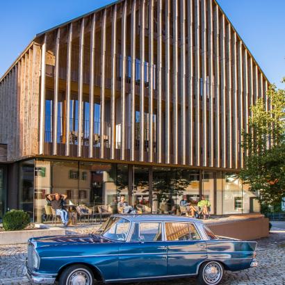 Roadbook Oldtimer Allgäu: 2020 meets 1960: Die Heckflosse vor der Fassade des "Allgäu Elgass Hotel"